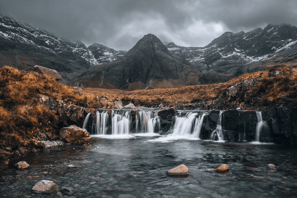 a waterfall with a mountain in the background
